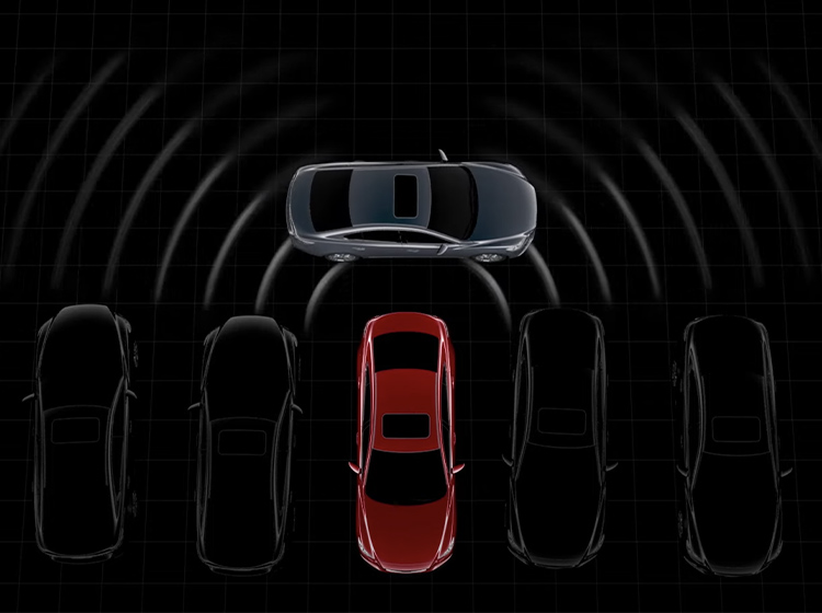 Vue aérienne d’une Mazda rouge reculant d’une file de voitures stationnées, de côté, avec le capteur radar à ondes millimétriques qui détecte des voitures qui doublent