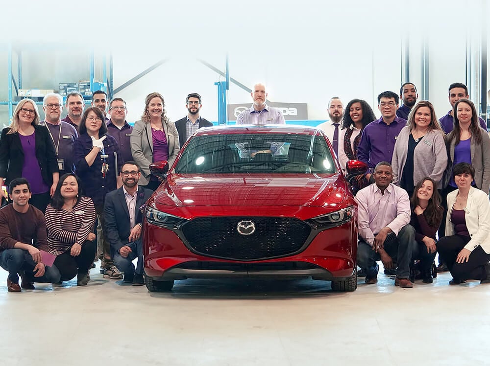 Photographie de l’équipe Mazda avec un véhicule au centre