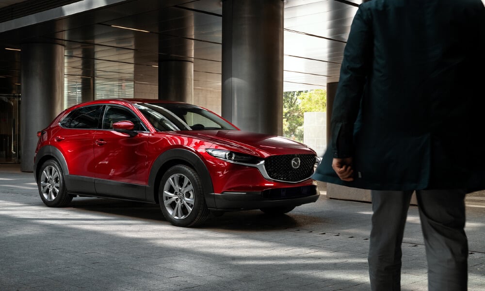 Soul red crystal metallic Mazda CX-5 parked in front of grey columns