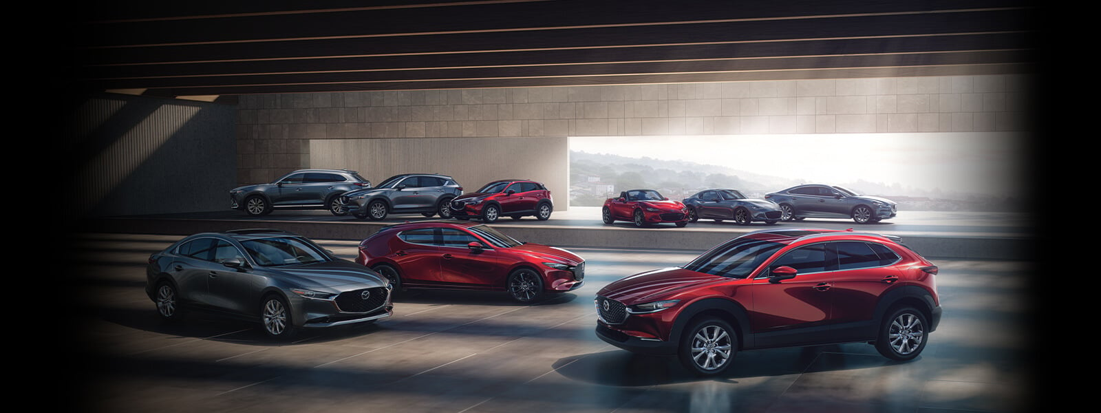 Salle d’exposition Mazda avec modèles VUM, VUS, berline, à hayon et décapotable