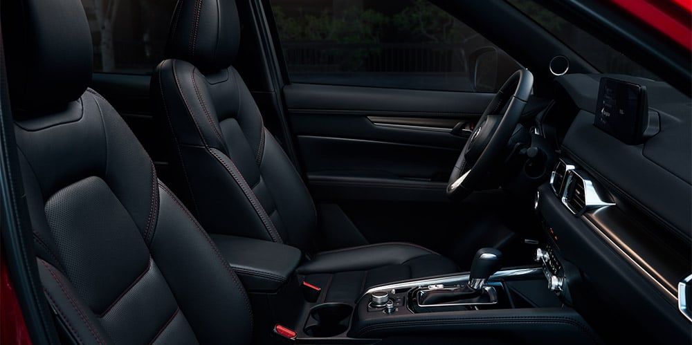 “Black leather-trimmed upholstery with red stitching.”