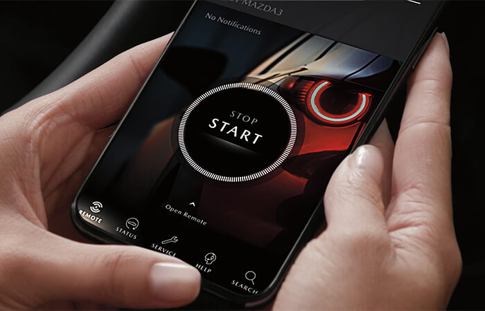 Smartphone with MyMazda app with vehicle start screen.