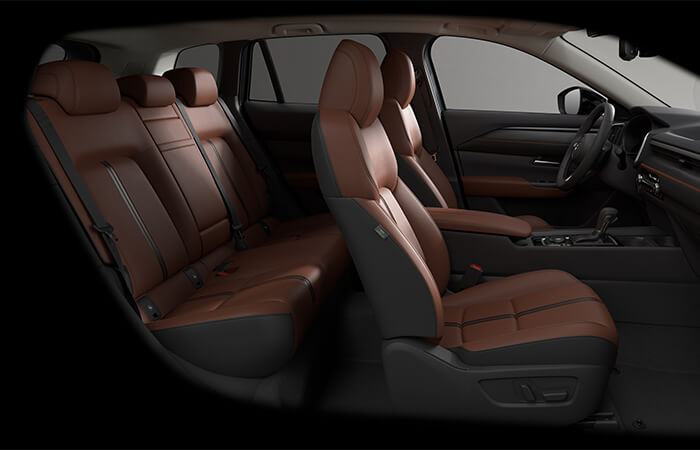 Interior side view showcasing terracotta leather seats with orange stitching.