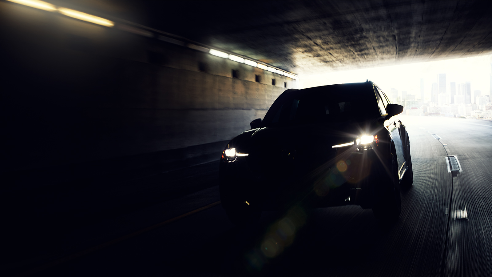 Shadowed shiloutte of CX-90 vehicle driving through a dark tunnel.