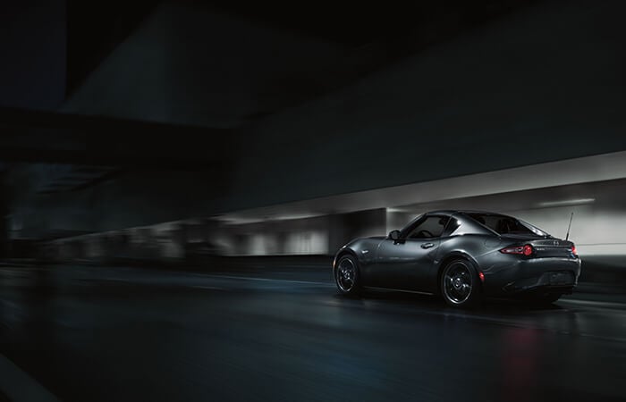 Gleaming Machine Grey Metallic Mazda MX-5 RF driving through blurred tunnel.