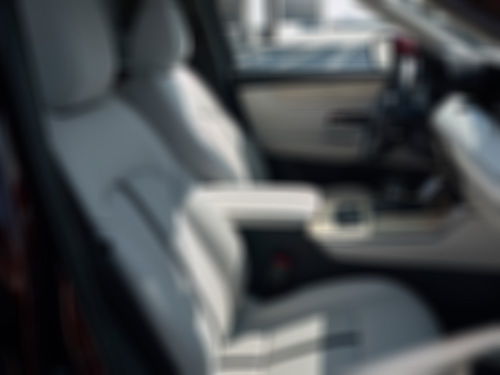 White Nappa leather seating, brushed metal and wooden details in the front seats of the CX-90. 
