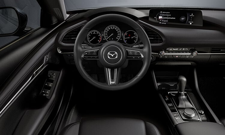 Vue du côté conducteur de l’habitacle d’une berline Mazda3. 