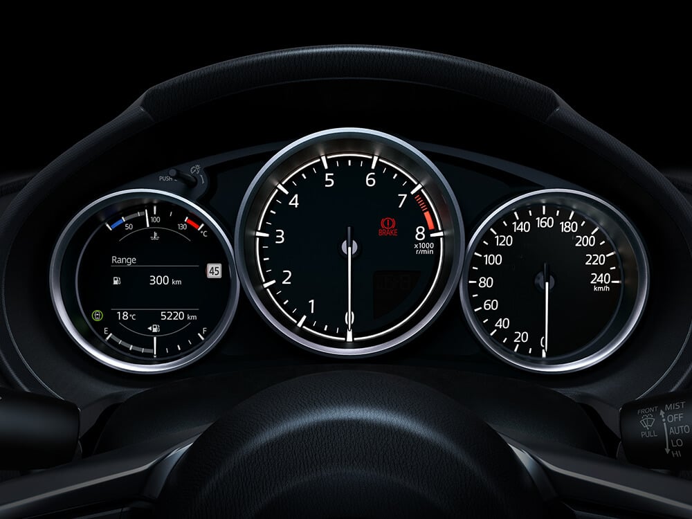 Closeup of the illuminated gauges behind the steering wheel show the MX-5 ST at rest. 