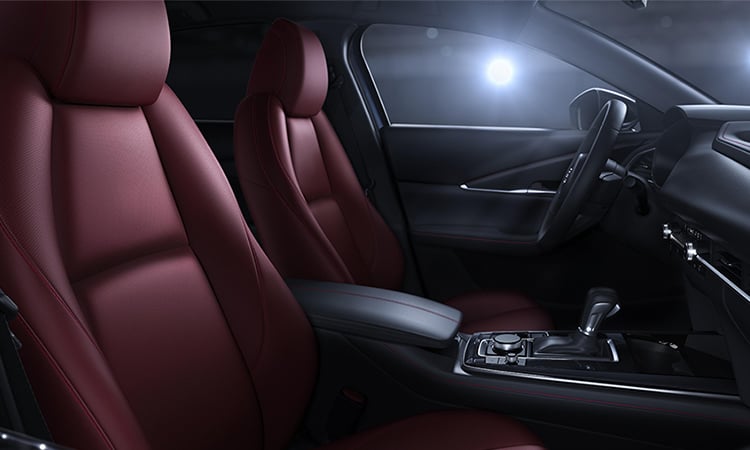 Vue dégagée des sièges en cuir rouge grenat du côté passager. 