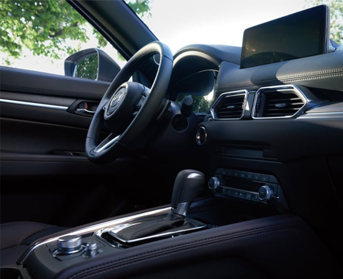 CX-5 steering wheel, dash, display and console seen low view from passenger seat.  