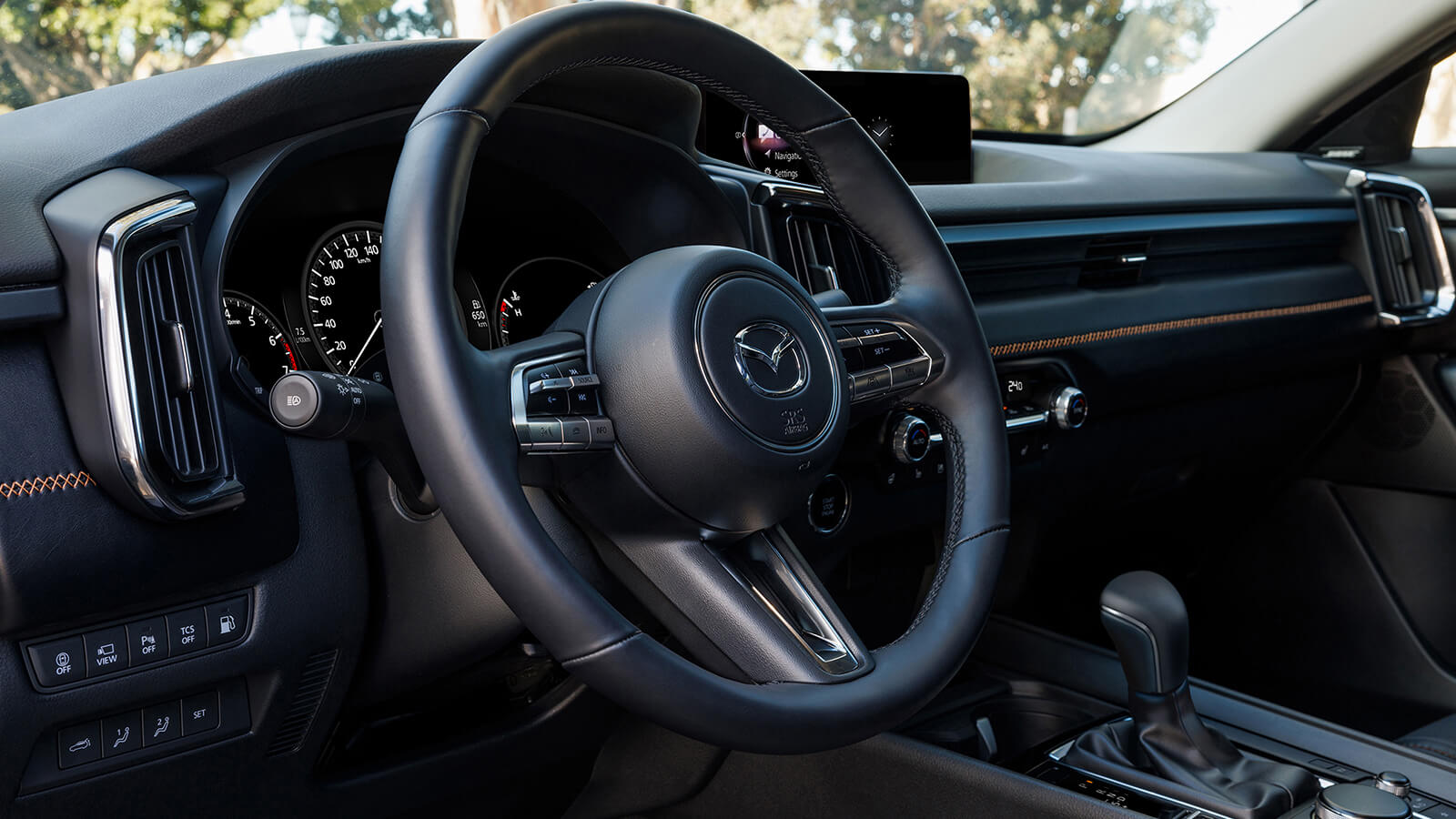 Close up of steering wheel, dashboard, console, shifter, and displays in CX-50 Hybrid cockpit.