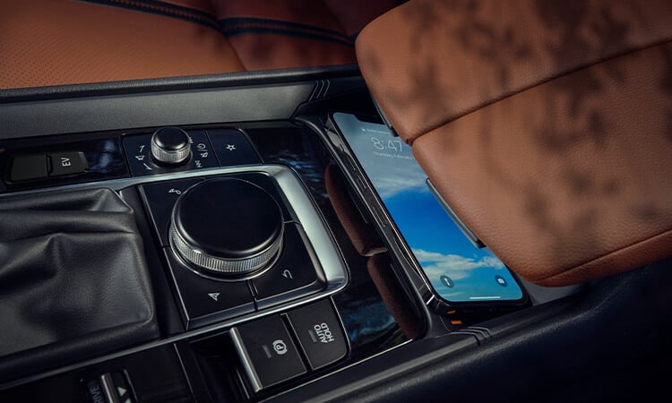 Close up of iPhone lying on charging pad in cockpit.