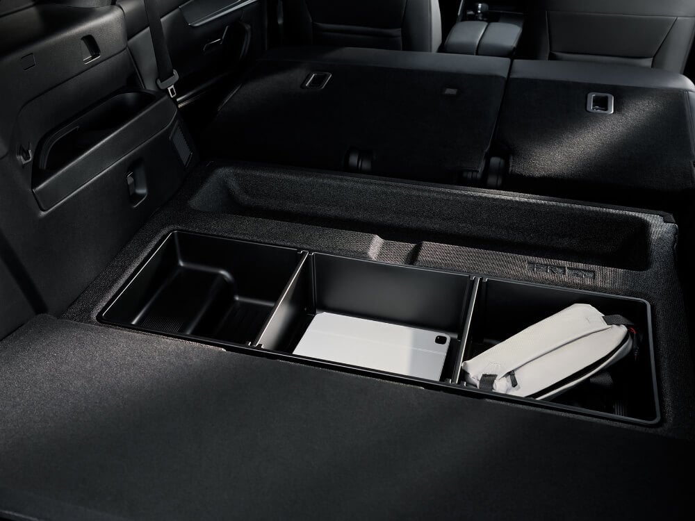 Closeup of storage space in the back of the CX-70, the second row is folded down with compartments opened for extra storage space.