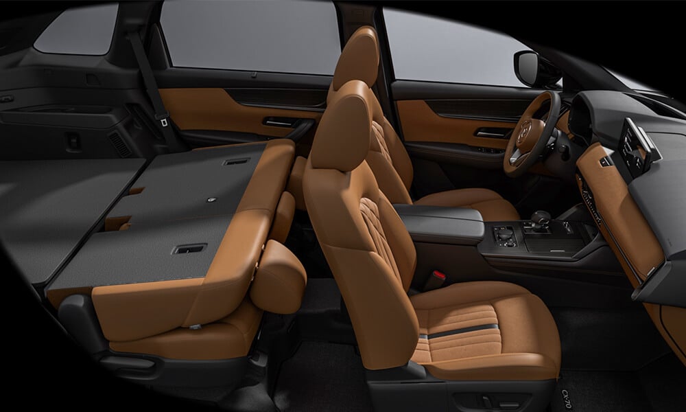 Interior shot of the CX-70 from the passenger’s side shows the second row folded down to create a larger cargo area.