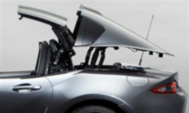 Image of a silver MX-5 RF hard top in the process of being retracted.